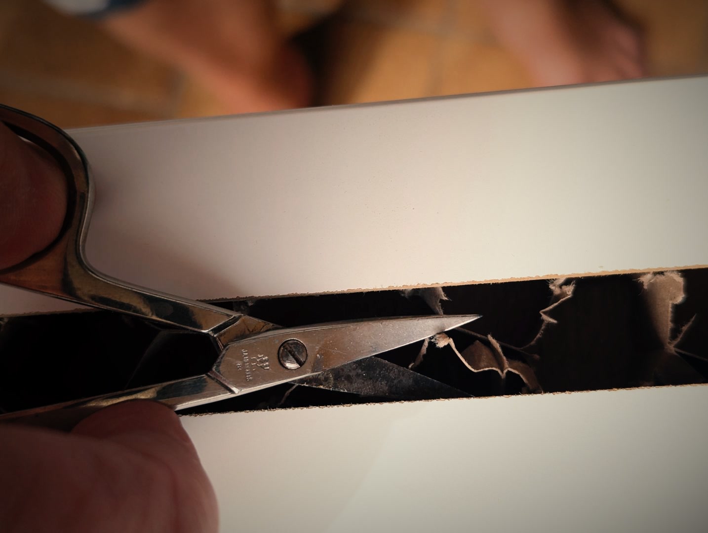 Cardboard is cut with scissors